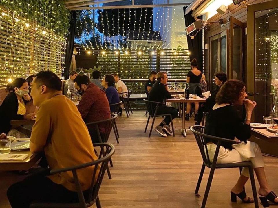 Couples having dinner on the string light adorned patio of L'Antica Pizzeria D'Michele