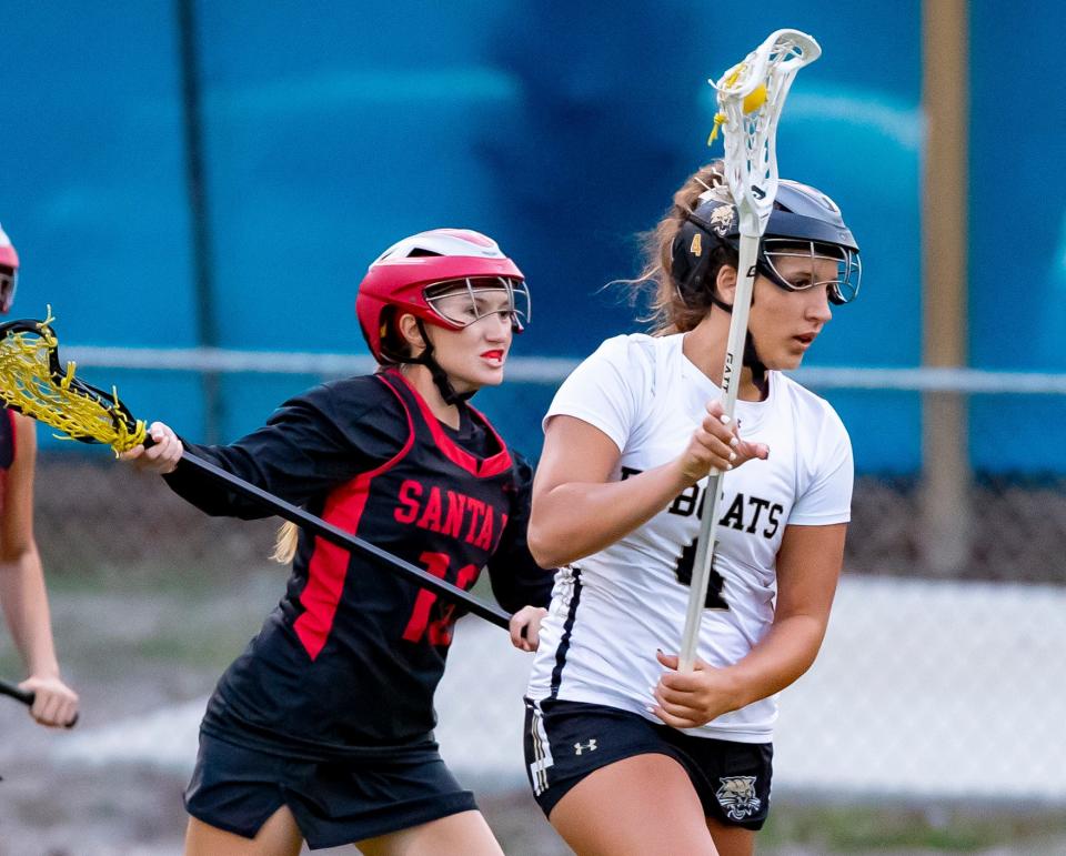 Santa Fe attack Addison Peak (10) chases down Buchholz midfielder Christine Cama (4) during a high school lacrosse game as Buchholz High School takes on Santa Fe high school at Boys and Girls Club in Gainesville, FL on Tuesday, March 21, 2023. [Alan Youngblood/Gainesville Sun]