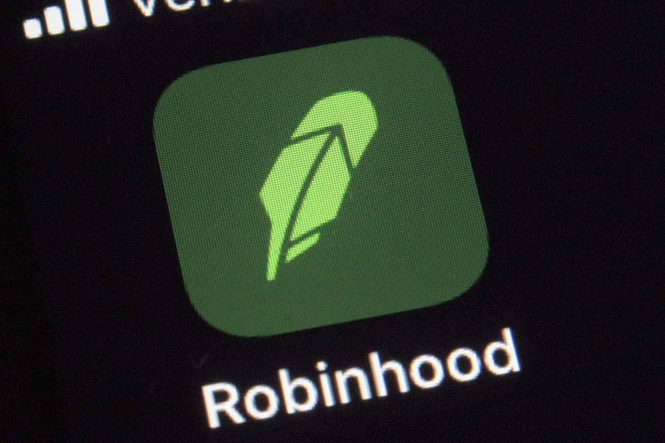 FILE - This  Dec. 17, 2020 file photo shows the logo for the Robinhood app on a smartphone in New York.  The online trading platform Robinhood is moving to restrict trading in GameStop and other stocks that have soared recently due to rabid buying by smaller investors.    (AP Photo/Patrick Sison)