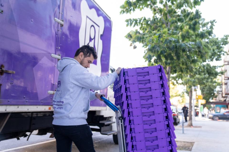 A Perfect Moving NYC employee loads up some plastic bins for a move