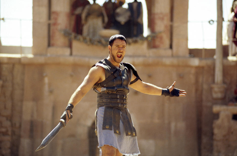 A man stands in the middle of a fight, waving his sword