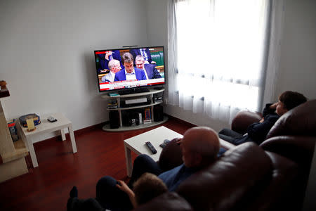 Alf Brewer, 66, a British retiree living in Spain, sits with his grandchildren as they watch on a TV screen a live debate of MPs at the Houses of Parliament in London, ahead of a vote on Prime Minister Theresa May's Brexit deal, at his home in Benalmadena, southern Spain January 15, 2019. REUTERS/Jon Nazca