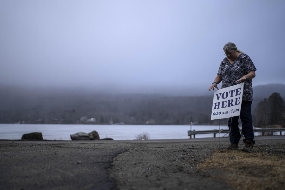 Town Clerk Sandra Lacasse, places a sign outside the town office as polls opens Tuesday, March 5, 2024, in Elmore, Vt. Super Tuesday elections are being held in 16 states and one territory. Hundreds of delegates are at stake, the biggest haul for either party on a single day. (AP Photo/David Goldman)