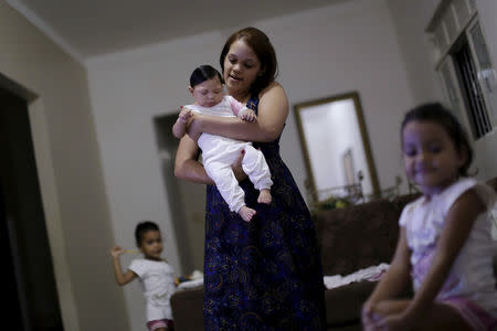 Gabriela Alves de Azevedo holds her four-month-old daughter Ana Sophia, who was born with microcephaly, at their house in Olinda, Brazil, March 2, 2016. REUTERS/Ueslei Marcelino/Files