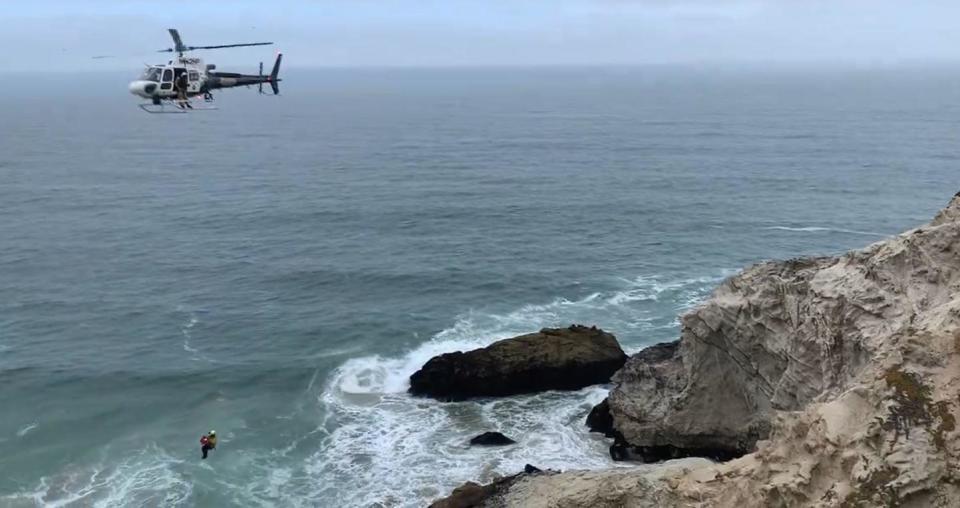 A CHP helicopter positions itself over a vehicle that plunged off a cliff along Highway 1 in Montara, April 18, 2024. / Credit: Cal Fire