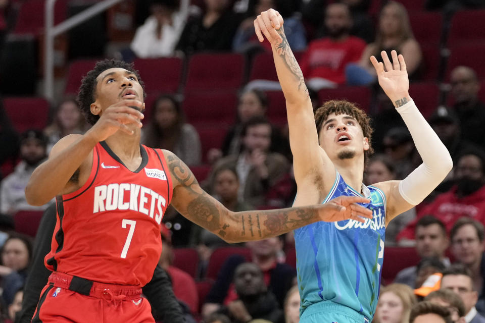 Charlotte Hornets guard LaMelo Ball, right, watches his three point basket as Houston Rockets guard Armoni Brooks (7) defends during the first half of an NBA basketball game, Saturday, Nov. 27, 2021, in Houston. (AP Photo/Eric Christian Smith)
