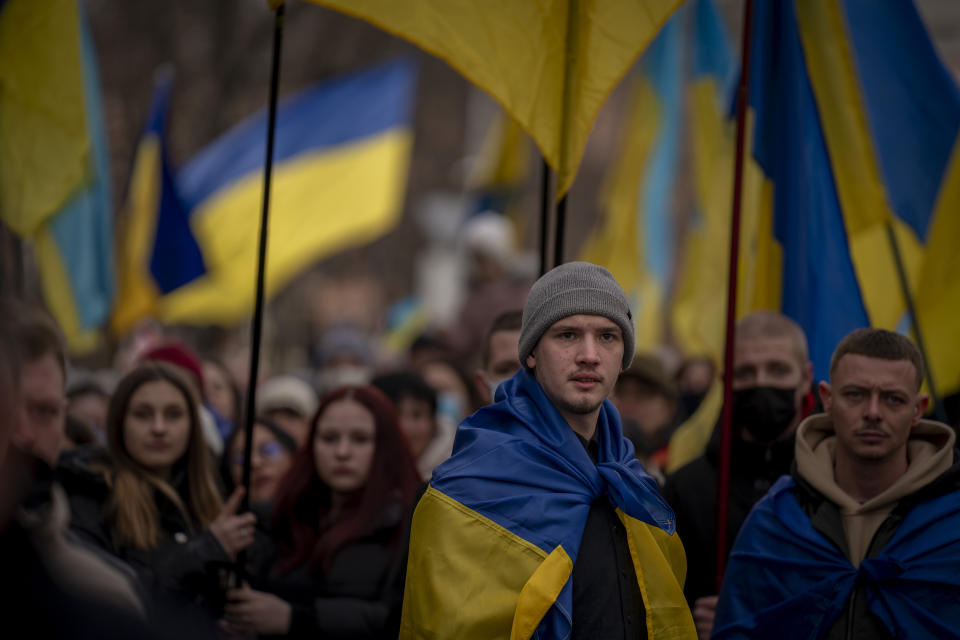 Demonstrators march along the street in Odessa, Ukraine, Sunday, Feb. 20, 2022. Thousands of people in Odessa marched through the streets of the city in a show of unity on Sunday, marking the date on which, eight years ago, more than a hundred people were killed during Ukraine's Maidan revolution. Waving national flags and placards with slogans such as, 'No Putin, No Cry', people said they had come out to demonstrate against a potential Russian invasion, and said that they were prepared to defend their city if needed. (AP Photo/Emilio Morenatti)