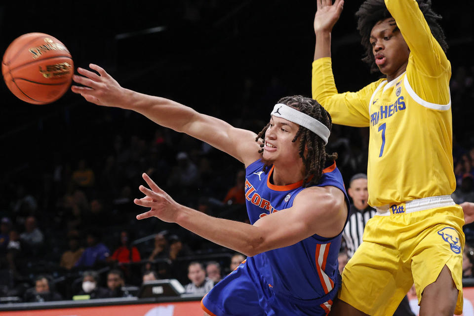 Florida guard Walter Clayton Jr. passes the ball away from Pittsburgh guard Carlton Carrington (7) during the second half of an NCAA college basketball game in the NIT Season Tip-Off on Wednesday, Nov. 22, 2023, in New York. (AP Photo/Eduardo Munoz Alvarez)