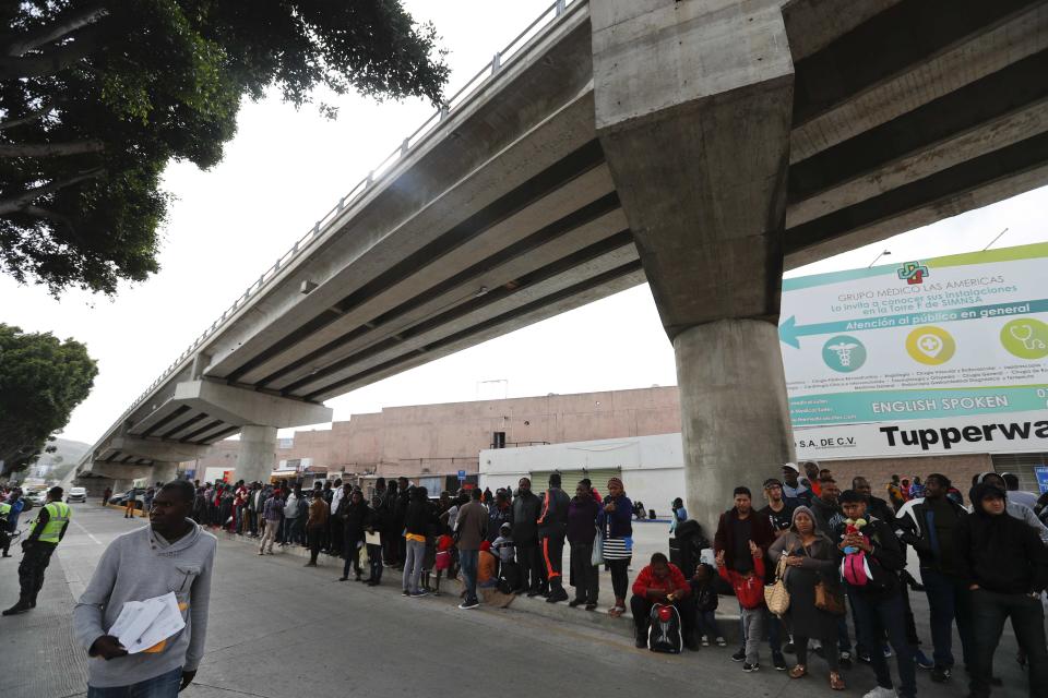 Migrants wait under a bridge to be attended to apply for asylum in the U.S., on the border in Tijuana, Mexico, Sunday, June 9, 2019. The mechanism that allows the U.S. to send migrants seeking asylum back to Mexico to await resolution of their process has been running in Tijuana since January. (AP Photo/Eduardo Verdugo)