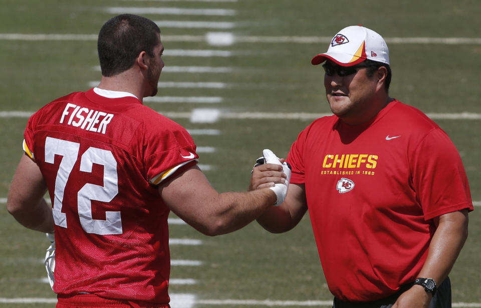 Kansas City Chiefs tackle Eric Fisher (72) shakes hands with assistant offensive line coach Eugene Chung, right, during NFL football training camp in St. Joseph, Mo., Friday, July 26, 2013. (AP Photo/Orlin Wagner)