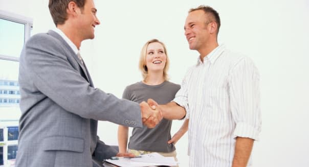 Real estate agent shaking hands with couple