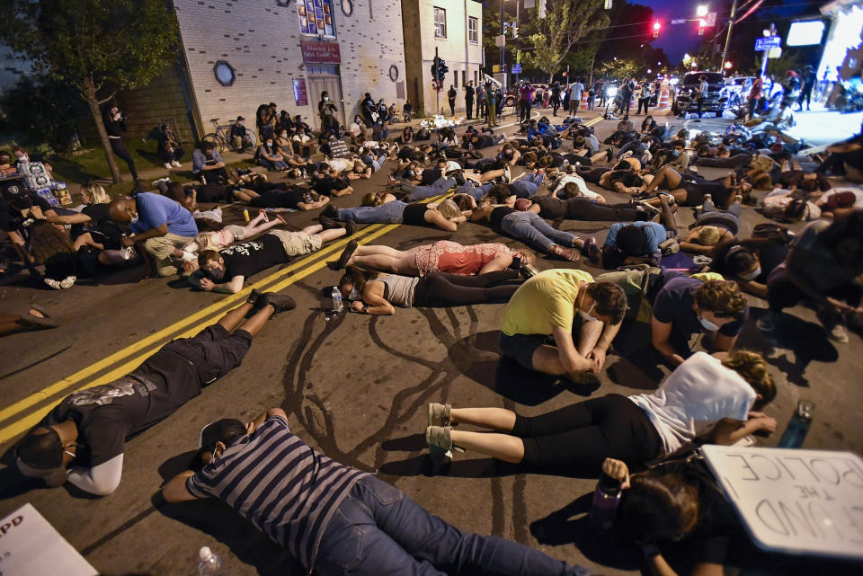 Demonstrators lie in the street Thursday, Sept. 3, 2020, at the site where Daniel Prude was restrained by police in Rochester, N.Y. Seven police officers involved in the suffocation death of Daniel Prude in Rochester were suspended Thursday by the city's mayor, who said she was misled for months about the circumstances of the fatal encounter. (AP Photo/Adrian Kraus)