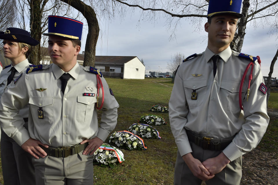 French soldiers stand next wreaths of flowers as they prepare for a ceremony with French President Emmanuel Macron to pay tribute to French soldiers who died in Mali helicopter crash, Monday Jan.13, 2020 in Pau, southwestern France. France is preparing its military to better target Islamic extremists in a West African region that has seen a surge of deadly violence. (AP Photo/Alvaro Barrientos, Pool)