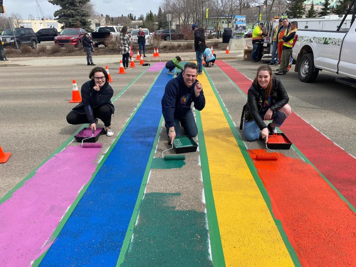 Community members along with Outloud founder Terry Soetaert paint a Pride crosswalk in St.Albert, Alta. The organization started to provide a safe space and resources for 2SLGBTQ+ youth and their families. The organization announced Friday it would be ceasing operations. (Outloud - image credit)