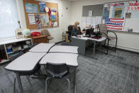 Sue Ziel, a sixth grade social studies teacher at Romeo Middle School, works in her classroom in Romeo, Mich., Tuesday, April 27, 2021. “I remember sitting in tears and telling my husband ‘I don’t know if I can do this,’ and those words have never come out of my mouth,” she said as the pandemic hit. Ziel left a job in advertising 24 years ago to teach. Even before then, she said the demands of the job had increased. (AP Photo/Paul Sancya)