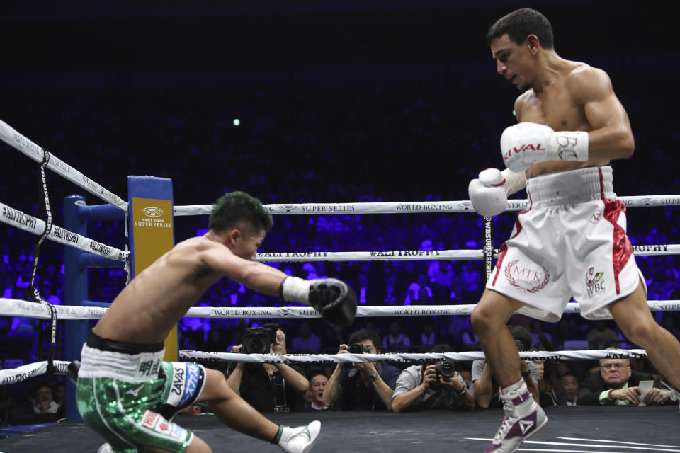 France's Nordine Oubaali, right, looks at Japan's Takuma Inoue falling down a mat in the fourth round of their WBC world bantamweight title match in Saitama, Japan, Thursday, Nov. 7, 2019. Oubaali defeated Inoue by a unanimous decision. (AP Photo/Toru Takahashi)