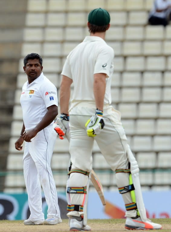 Sri Lanka's Rangana Herath (L) dismisses Australia's Mitchell Marsh (R) on the final day of the opening Test in Pallekele on July 30, 2016