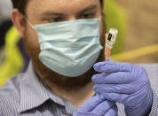 North East Ohio Medical University student William Puthoff prepares a dose of Johnson & Johnson COVID-19 vaccine at Kent State University in Kent, Ohio, Thursday, April 8, 2021. U.S. colleges hoping for a return to normalcy next fall are weighing how far they should go in urging students to get the COVID-19 vaccine, including whether they should — or legally can — require it. (AP Photo/Phil Long)