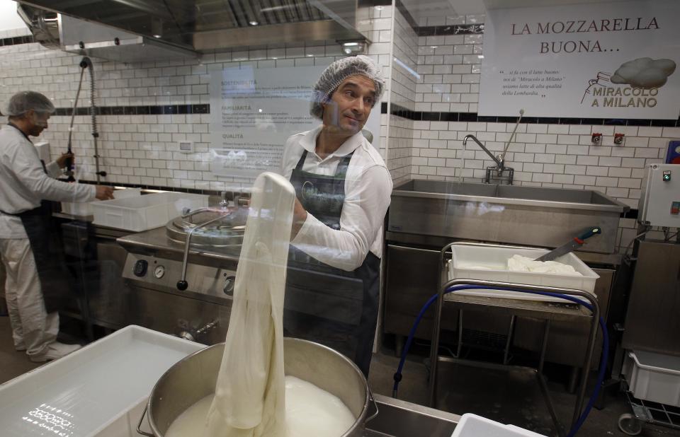 An employee makes fresh mozzarella during the opening day of upmarket Italian food hall chain Eataly's flagship store in downtown Milan, March 18, 2014. Eataly, which began with the idea that there should be a place to buy, eat and study high-quality Italian food and wine, has 25 food emporiums in the United States, Turkey, Japan and Dubai. REUTERS/Alessandro Garofalo (ITALY - Tags: SOCIETY FOOD BUSINESS)