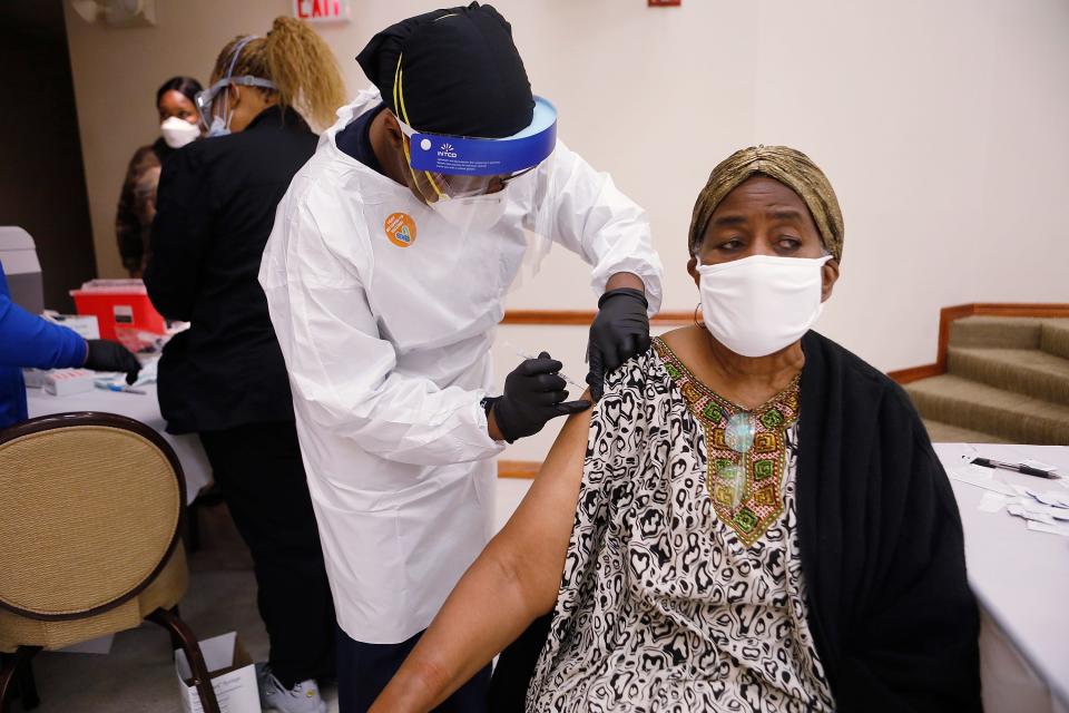 A healthcare worker administers the COVID-19 vaccine to a resident living in the Jackson Heights neighborhood at St. Johns Missionary Baptist Church on Jan. 10, 2021, in Tampa, Florida. The Florida Department of Health is targeting the underserved populations that are most vulnerable to getting the coronavirus, specifically the African and Latin American communities.