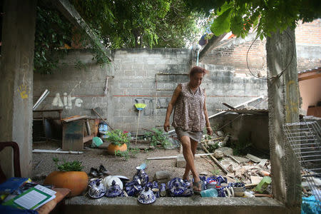 Felina, 50, an indigenous Zapotec transgender woman also know as Muxe, walks on the crockery inside her house destroyed after an earthquake that struck on the southern coast of Mexico late on Thursday, in Juchitan, Mexico, September 10, 2017. Picture taken, September 10, 2017. REUTERS/Edgard Garrido