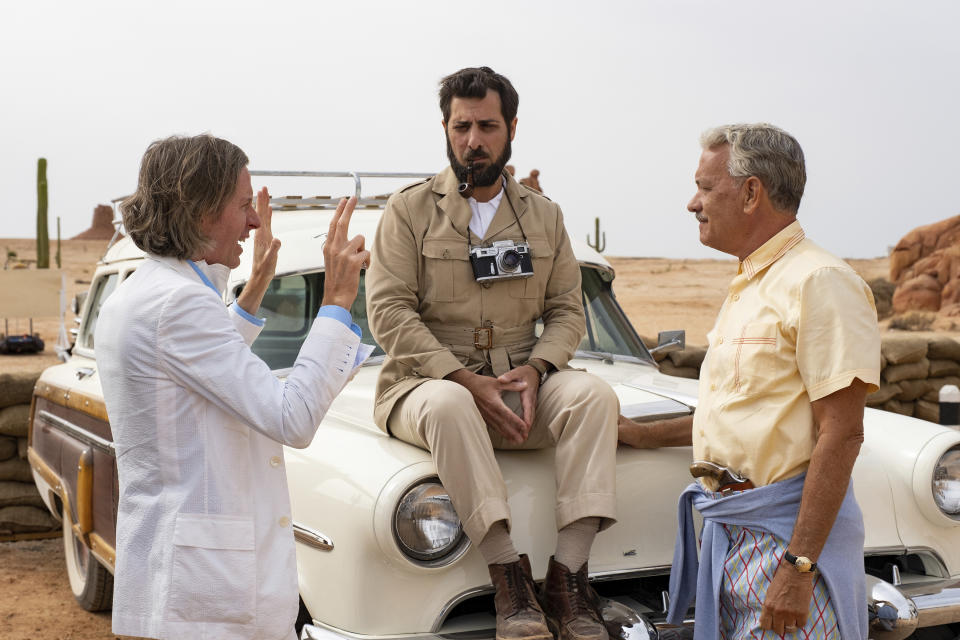 This image released by Focus Features shows writer/director Wes Anderson, left, with actors Jason Schwartzman, center, and Tom Hanks on the set of "Asteroid City." (Roger Do Minh/Focus Features via AP)