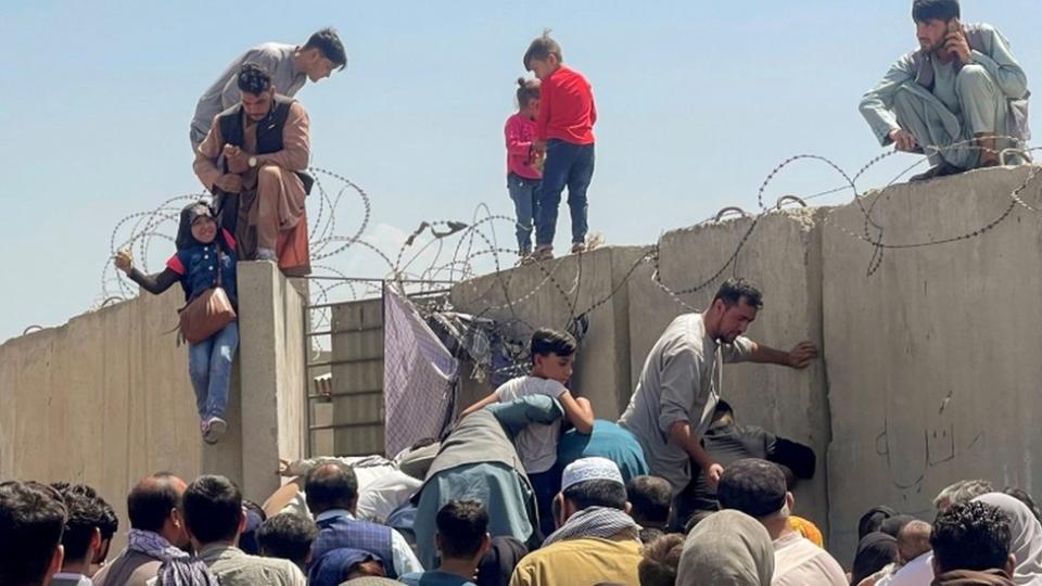 A man pulls a girl to get inside Hamid Karzai International Airport in Kabul, Afghanistan August 16, 2021