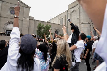 Fans gather and point to the sky in unison at Forest Lawn Cemetery, ten years after the death of child star turned King of Pop, Michael Jackson, in Glendale, California