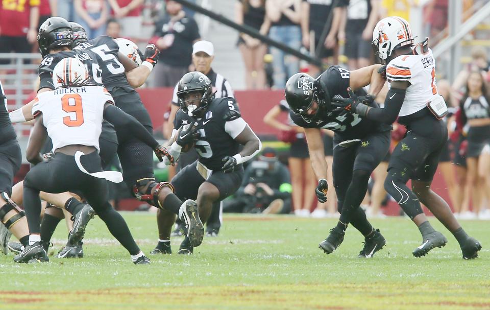 Iowa State Cyclones' running back Cartevious Norton (5) attempts to run between Oklahoma State Cowboys' safety Trey Rucker (9) and linebacker Xavier Benson ( 1)during the first quarter of an NCAA college football game at Jack Trice Stadium on Saturday, Sept. 23, 2023, in Ames, Iowa.