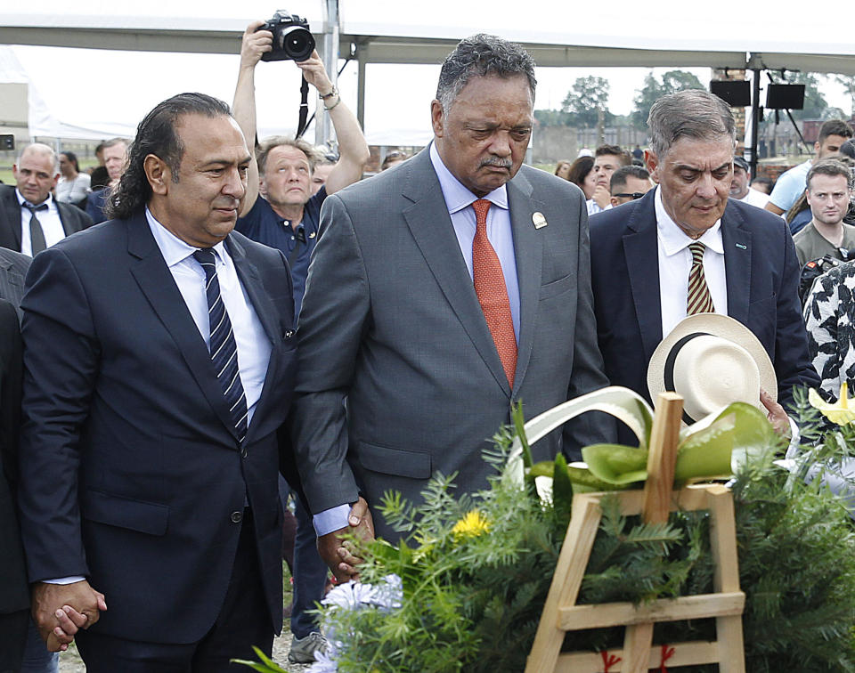 US civil rights activist Jesse Jackson center, Romany activist and head of the Central Council of German Sinti and Roma Romani Rose, right, and Roma leader Roman Kwiatkowski lay flowers at the memorial site of the former Auschwitz-Birkenau German Nazi Death Camp, in Oswiecim, Poland, Friday, Aug. 2, 2019. Jackson prayed and mourned at Auschwitz-Birkenau on Friday as he joined survivors paying homage to an often forgotten genocide — that of the Roma people — on a key 75th anniversary. In addition to the 6 million Jews killed in camps such as Auschwitz, the Nazis killed other minorities during World War II, including between 250,000 and 500,000 Roma and Sinti. (AP Photo/Czarek Sokolowski)