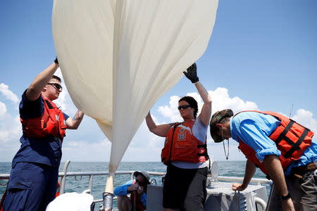 Students and faculty with the College of Charleston and the US Coast Guard, prepare to launch a test balloon for the Space Grant Ballooning Project, in preparations for Monday's solar eclipse on board a US Coast Guard response boat at sea near Charleston, South Carolina, U.S. August 17, 2017. Location coordinates for this image are 32º41' 975" N 79º44'195" W. REUTERS/Randall Hill