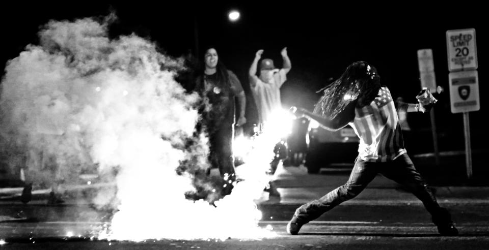 Edward Crawford Jr. returns a tear gas canister fired by police who were trying to disperse protesters in Ferguson, Missouri, on  Aug. 13, 2014. (Photo: Robert Cohen/St. Louis Post-Dispatch/AP)