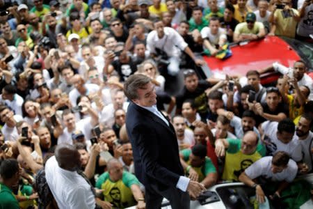 Federal deputy Jair Bolsonaro, a pre-candidate for Brazil's presidential election, is greeted by supporters as he arrives at Luis Eduardo Magalhaes International Airport in Salvador, Brazil May 24, 2018. Picture taken May 24, 2018. REUTERS/Ueslei Marcelino
