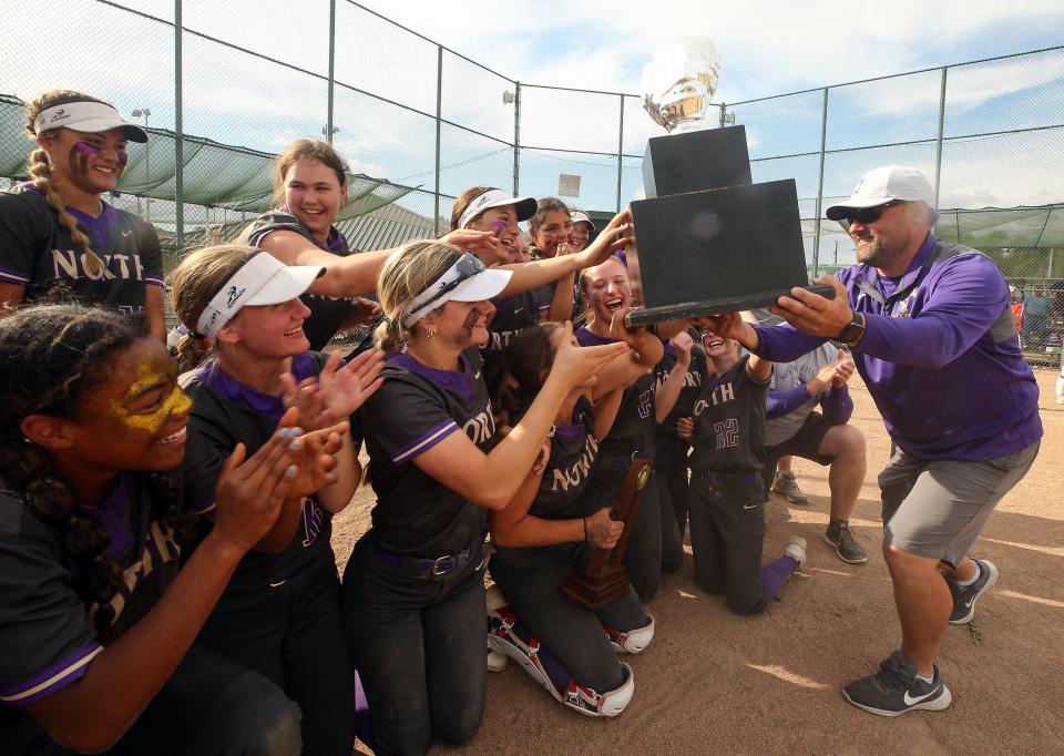 North Kitsap athletic director Matt Stanford hands the championship trophy to the Vikings softball team after their Class 2A title game 8-1 win over Ridgefield at Carlon Park in Selah on Saturday, May 27, 2023.
