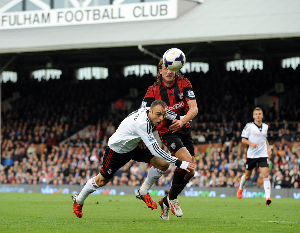 Fulham's Dimitar Berbatov (right) is tackled by WBA'S Jonas Olsson during the Barclays Premier League match at Craven Cottage, London.