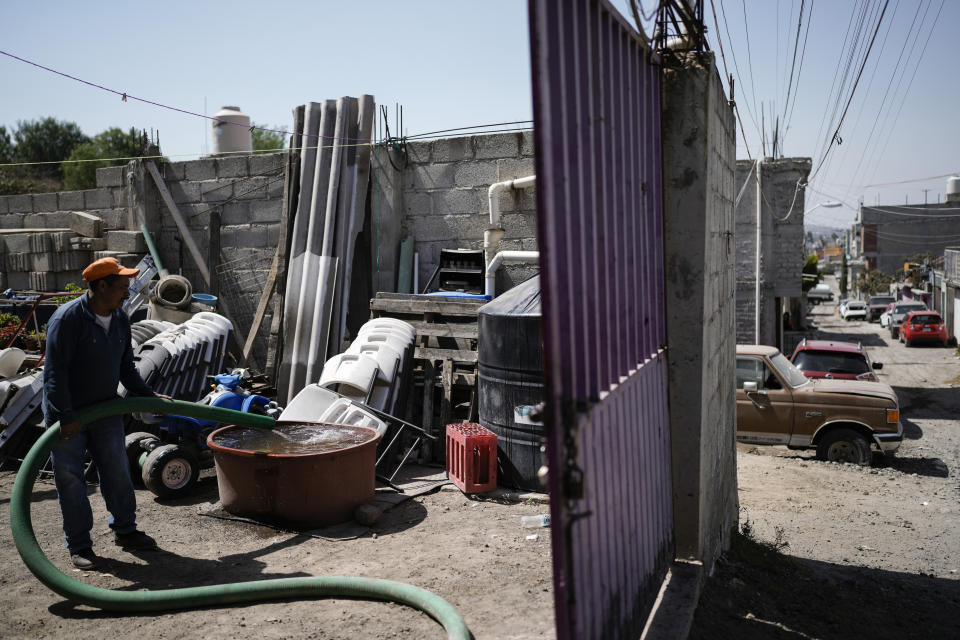 A worker delivers water to a home in Iztapalapa, on the outskirts of Mexico City, Wednesday, March 6, 2024. Sprawling Mexico City gets its water from over-tapped underground aquifers and a vast network of canals, dams and reservoirs called the Cutzamala System. (AP Photo/Eduardo Verdugo)