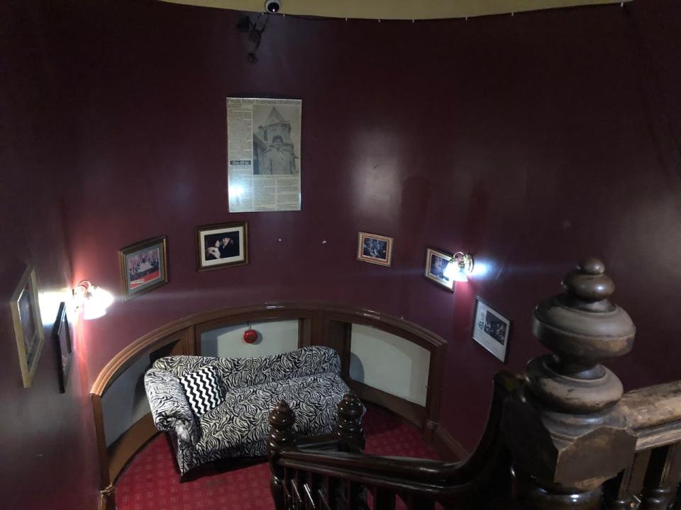 A stairwell in The Manor with various photos depicting the building's history.