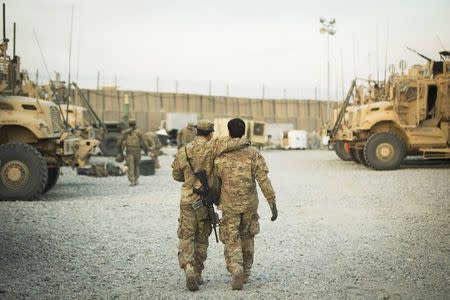 A U.S. soldier from the 3rd Cavalry Regiment walks with the unit's Afghan interpreter before a mission near forward operating base Gamberi in the Laghman province of Afghanistan in this December 11, 2014 file photo. REUTERS/Lucas Jackson/Files