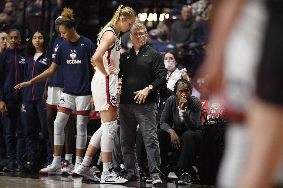 Connecticut head coach Geno Auriemma, center right, talks with Dorka Juhasz (14) in the first half of an NCAA college basketball game against Louisville, Sunday, Dec. 19, 2021, in Uncasville, Conn. (AP Photo/Jessica Hill)