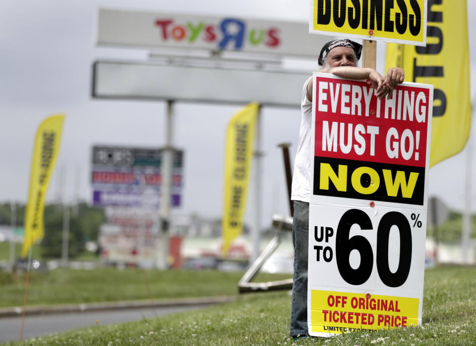 A man holds up a sign announcing the going out of business sale at a Toys R Us and Babies R Us store location, Friday, June 1, 2018, in Totowa, N.J. Politicians, including U.S. Sen. Bob Menendez and Sen. Cory Booker, held a news conference at the Totowa location to voice their concerns after it was announced that employees will not get severance packages once the stores are closed following the bankruptcy of the company. (AP Photo/Julio Cortez)