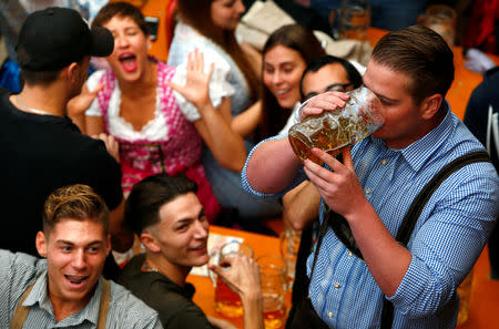 FILE PHOTO: A visitor drinks beer during the opening day of the 184th Oktoberfest in Munich, Germany, September 16, 2017. REUTERS/Michaela Rehle/File Photo