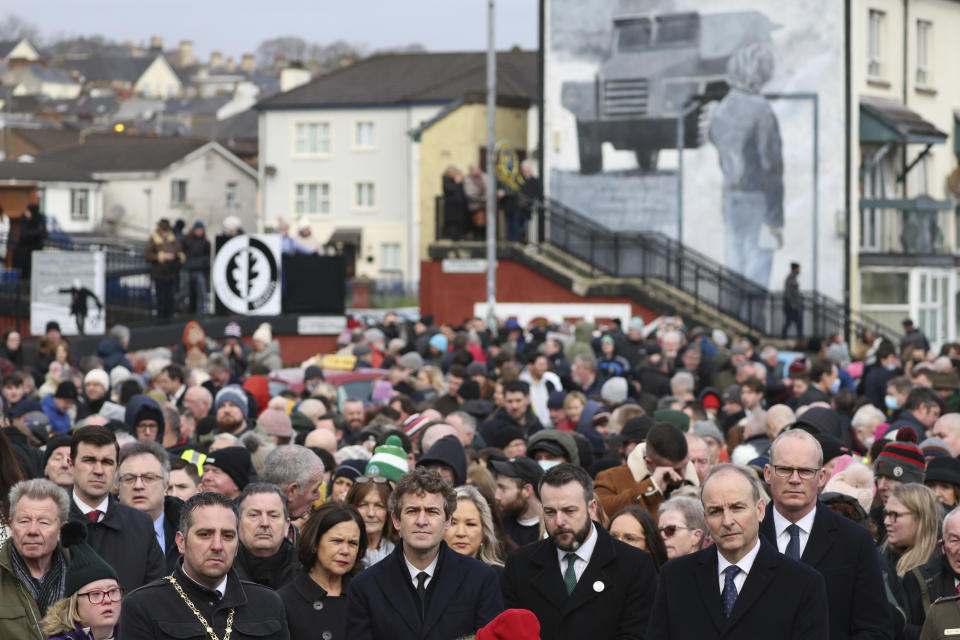 The Irish Prime Minister Micheal Martin, front right, pays his respects to the victims of Bloody Sunday during a march to commemorate the 50th anniversary of the 'Bloody Sunday' shootings in Londonderry, Sunday, Jan. 30, 2022. In 1972 British soldiers shot 28 unarmed civilians at a civil rights march, killing 13 on what is known as Bloody Sunday or the Bogside Massacre. Sunday marks the 50th anniversary of the shootings in the Bogside area of Londonderry .(AP Photo/Peter Morrison)