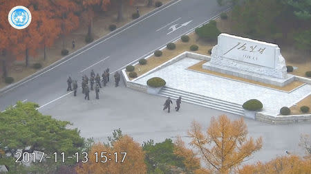 North Korean soldiers hold rifles and gather in the North Korean side of the Joint Security Area at the Demilitarized Zone between North and South Korea, in this still image taken from a video released by the United Nations Command (UNC) on November 22, 2017. United Nations Command/Handout via REUTERS