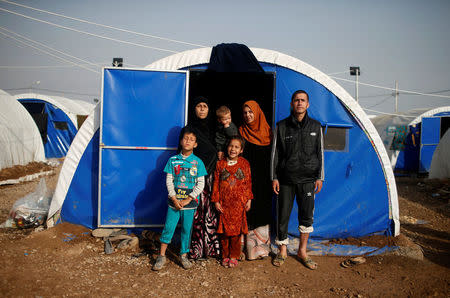 Displaced Iraqi Gorha Mahmoud (L), 40, poses for a photograph with family at Hammam al-Alil camp south of Mosul, Iraq, March 29, 2017. Gorha said she sees no future for her family even after the defeat of Islamic State. Her two children, being over six years old, attend morning classes in the camp's school just 200 meters away. It took the family 48 hours to reach the camp but they had to wait another 24 hours at the entrance gate, in the rain and the cold, before being authorised inside and given a tent. They have been in the camp for over a month. REUTERS/Suhaib Salem SEARCH "DISPLACED REFUGE" FOR THIS STORY. SEARCH "WIDER IMAGE" FOR ALL STORIES.