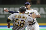 Milwaukee Brewers' Jace Peterson throws to first base to turn a double play after tagging out Pittsburgh Pirates' Jacob Stallings (58) at second base during the fourth inning of a baseball game Saturday, April 17, 2021, in Milwaukee. (AP Photo/Aaron Gash)