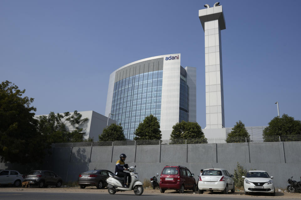 A motorist rides past Adani Corporate House in Ahmedabad, India, Friday, Jan. 27, 2023. Shares in India’s Adani Group plunged up to 20% on Friday and the company said it was considering legal action against U.S.-based short-selling firm Hindenburg Research for allegations of stock market manipulation and accounting fraud that have led investors to dump its stocks. (AP Photo/Ajit Solanki)