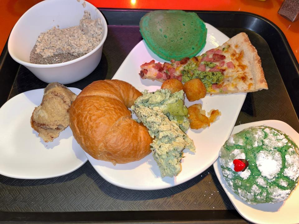 tray of food with croissant and green desserts