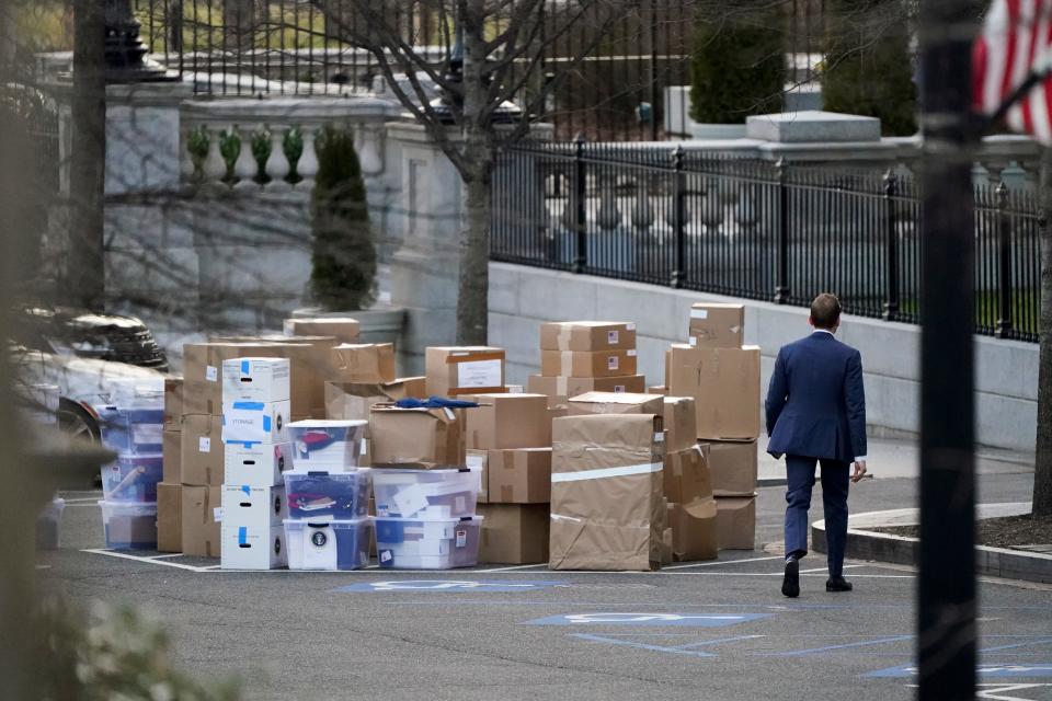People move boxes out of the Eisenhower Executive Office building inside the White House complex on Thursday, Jan. 14, 2021.