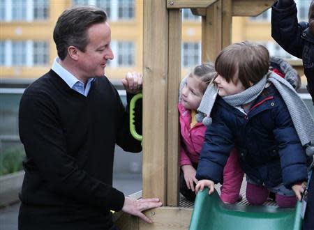 Children look at Britain's Prime Minister David Cameron during his visit to the Coin Street nursery in London March 18, 2014. Britain's coalition government unveiled a larger-than-expected scheme to help cut the cost of childcare for working parents on Tuesday in an appeal to voters squeezed by several years of stagnant wages and rising prices. REUTERS/Peter Macdiarmid/pool