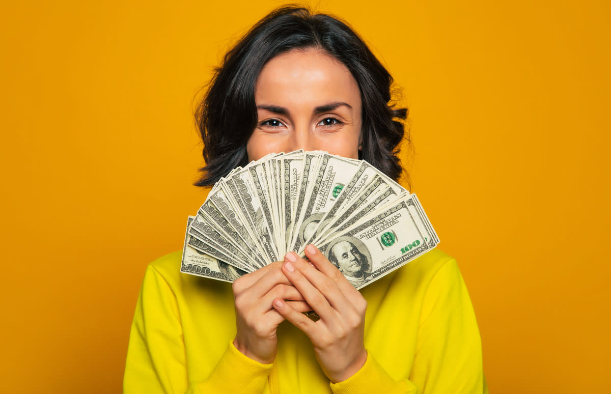 Woman holding money<p>iStock</p>